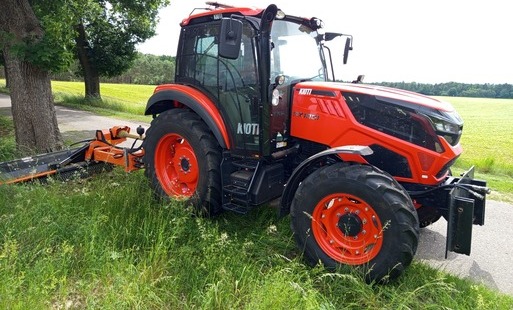 ciągnik koszący trawę na poboczu drogi